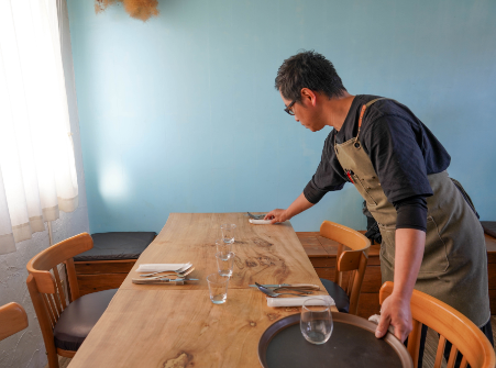 テーブルを拭いている男性